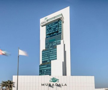 The image shows the Mubadala building, with "MUBADALA" displayed on the facade. This visually represents the institutional backing mentioned in the post, highlighting Mubadala Capital's $75M commitment coming on-chain through Solana.