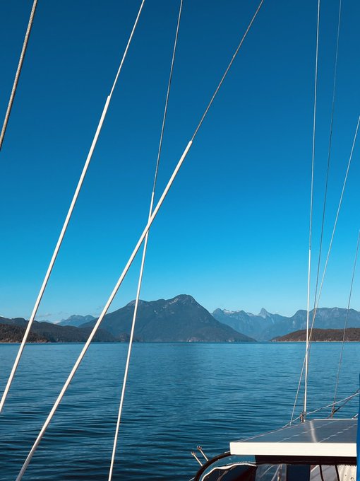 A view of blue mountains and water framed by yacht rigging, illustrating the expansive digital landscape suggested by the $apogee project.