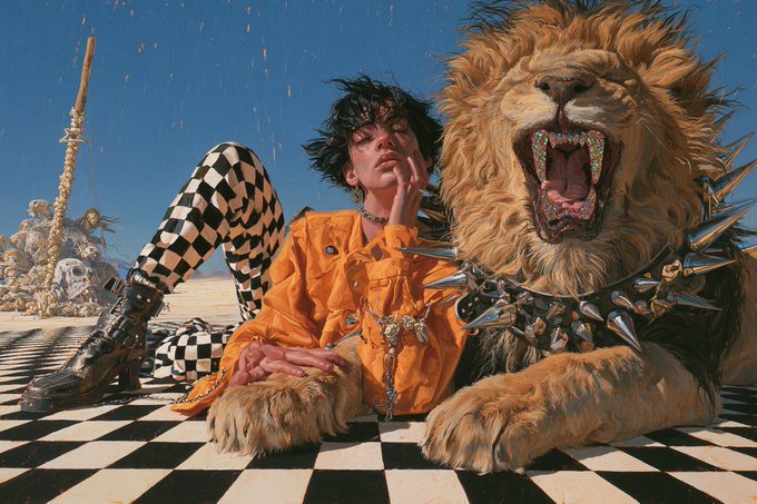 A stylishly dressed person in a checkered outfit lounges beside a fierce, snarling lion adorned with a spiked collar on a black-and-white checkered floor. The bold, untamed aesthetic complements the "Happy Friday" message, conveying a wild and liberating weekend vibe.