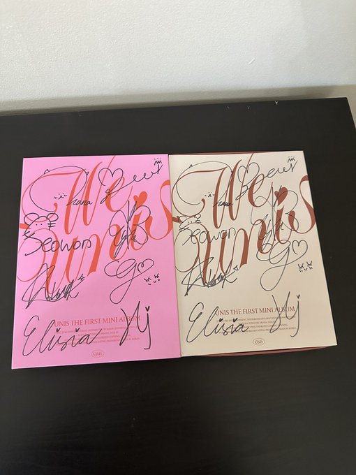 Two signed copies of Olivia Rodrigo's debut mini album 'GUTS' - one pink and one white/cream version - both covered in handwritten signatures including 'Olivia'.
