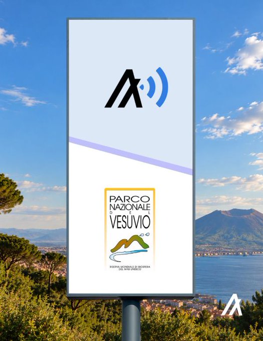 A sign with the AXA logo and 'PARCO NAZIONALE DEL VESUVIO' logo, set against a backdrop of the Bay of Naples with Mount Vesuvius visible.