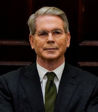 A formal portrait shows Treasury Secretary Scott Bessent, a gray-haired man in a dark suit and patterned tie, who is quoted in the accompanying post emphasizing the importance of the CLARITY Act for America to win the global crypto race.