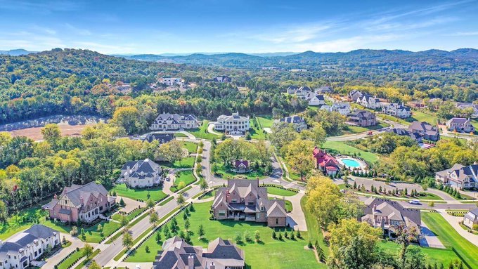 An aerial view of a luxurious suburban neighborhood featuring sprawling mansions nestled among lush green trees and rolling hills, perfectly complementing the post's message about the gap between 24/7 crypto markets and traditional real estate being bridged.

*Note: No text, numbers, tickers, or names are visible in the image itself.*