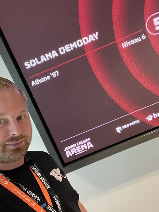 A selfie of a man with a beard wearing a Hacker House lanyard, taken at the Johan Cruijff Arena for the Solana Demoday event in Athene '87, Niveau 6.
