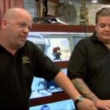Two men stand together in what appears to be a pawn shop setting reminiscent of the "Pawn Stars" TV show, with the context of the post discussing market manipulation through coordinated FUD drops—mirroring how a shop might unload questionable merchandise at the worst time for a buyer.