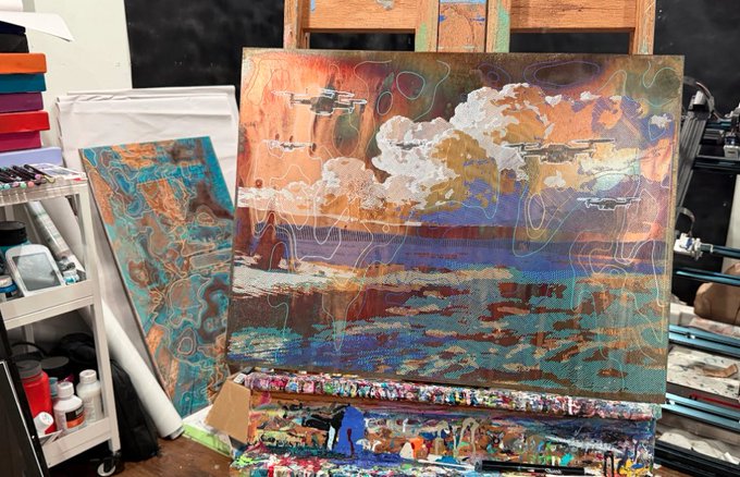 A textured mixed-media painting on canvas depicting a cloudy sky and seascape, displayed on an easel in an artist's studio.