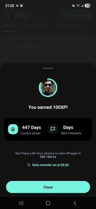 A mobile app screen displays a 'You earned 100XP!' reward notification, showing a current streak of 447 days with a teal 'Close' button at the bottom.