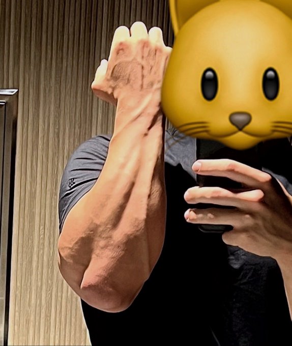 A flexed foot showing prominent veins and muscles, paired with a cat emoji covering the face, humorously illustrating the post's joke about "CAT coiners" being unusually jacked.