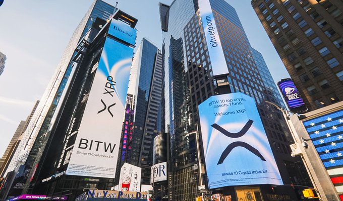 A low-angle shot of Times Square skyscrapers displaying large advertisements for Bitwise 10 Crypto Index ETF, featuring XRP branding.