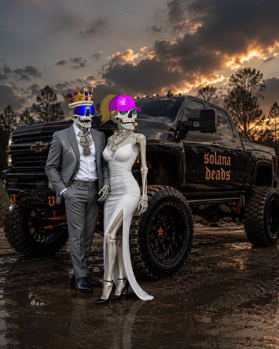 A skeletal couple in formal attire—a king in a crown and sunglasses beside a bride in a white gown and pink cap—pose in front of a black lifted truck emblazoned with "Solana Deads," embodying the community spirit and loyalty celebrated in the $DEADS project.