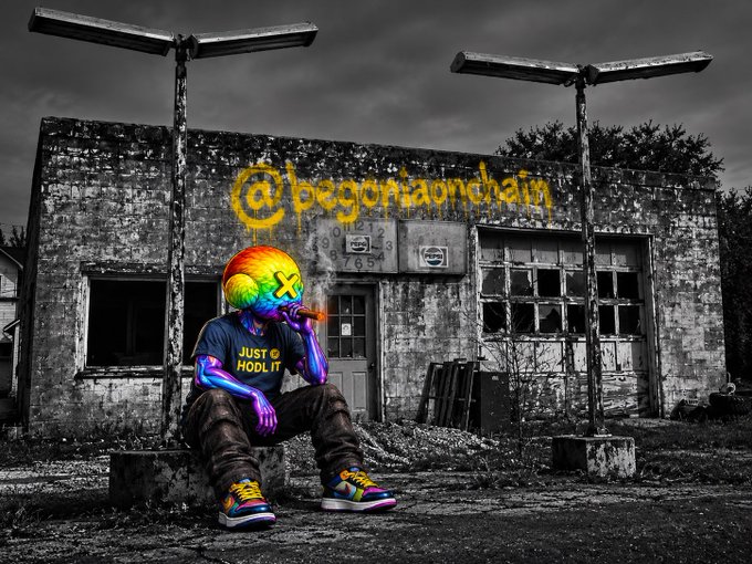 A surreal digital artwork featuring a rainbow-colored humanoid figure wearing a 'JUST HODL IT' t-shirt, sitting in front of a dilapidated building with yellow graffiti reading '@begoniaonchain'.