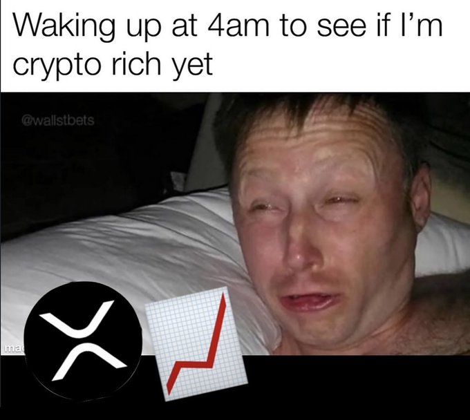 The image features a man lying down with his eyes closed, possibly sleeping or resting. There are two pieces of paper placed next to him - one has an XRPC symbol on it, while the other shows a graph. The text "Waking up at 4am to see if I'm crypto rich yet" is also present in the image.
