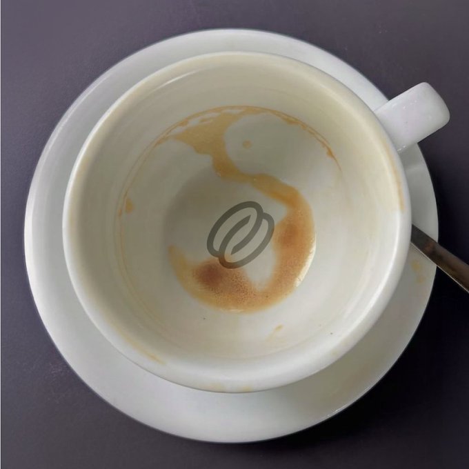 An empty white coffee cup on a saucer, with only coffee residue and foam remaining, features a coffee bean logo at the bottom. The image relates to the "Refuelled" post by symbolizing the completed act of refueling with coffee on Monday.