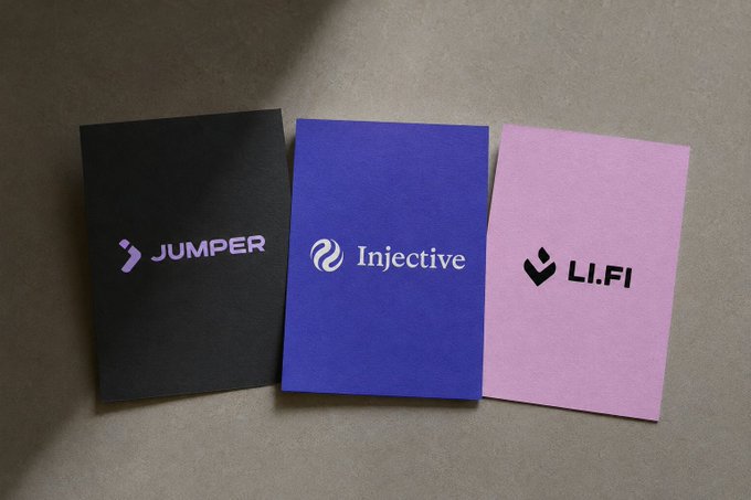 Three promotional brochures laid out on a gray surface, displaying the logos for 'JUMPER' (black), 'Injective' (purple), and 'LI.FI' (pink).