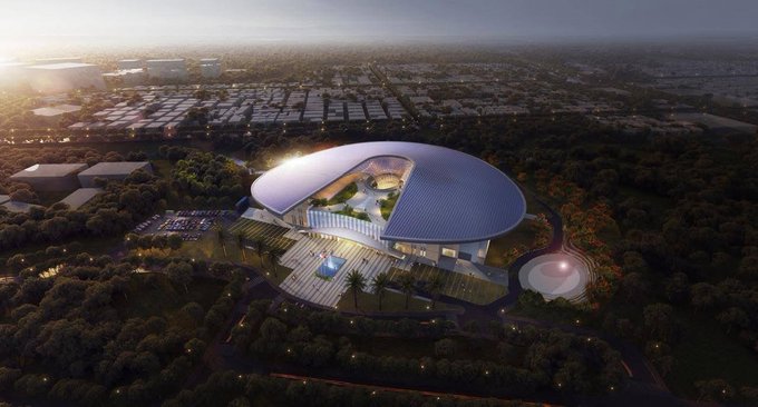 The image shows an aerial view of a large building with a dome-like shape located in El Salvador, Mexico. The building appears to be a modern architectural structure that could potentially serve as a hub for innovation, technology, or international events. The surrounding area is filled with trees and other buildings, indicating the city's urban setting. The image also includes text that reads "El Salvador is building the future. Construction of the new CIFCO is now underway, creating what could become Central America's leading hub for innovation, technology, and international events". This suggests that the construction project in El Salvador is not only a significant development but also has the potential to shape the city's future and attract global attention.