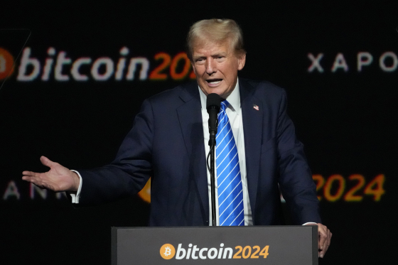 Donald Trump speaks at a podium with "bitcoin2024" displayed, a fitting backdrop for his comments on cryptocurrency's increasing use and status as an asset.