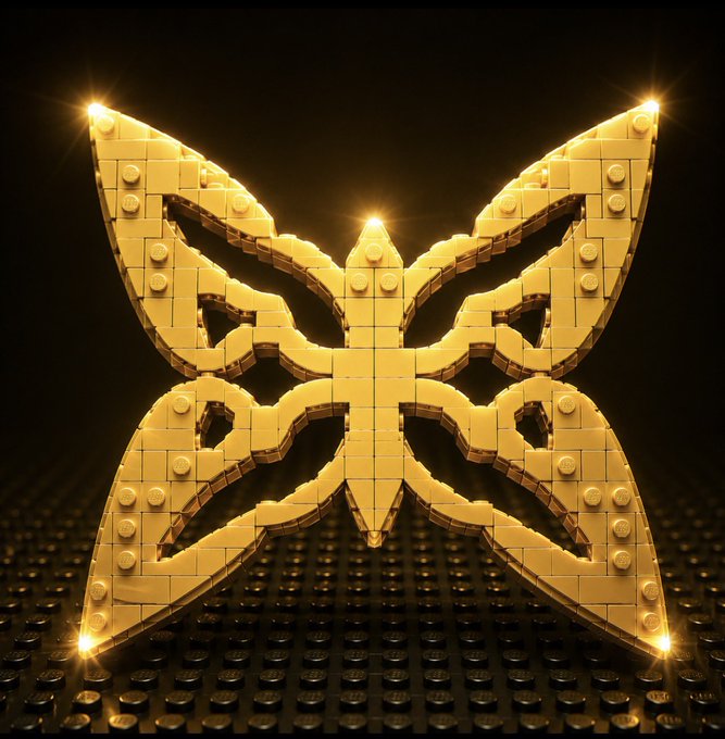 A glowing golden butterfly sculpture made entirely of LEGO bricks, featuring intricate wing patterns and bright highlights against a dark background.