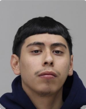 The image appears to be a mugshot-style photo of a young man with dark hair and a faint mustache, shown against a plain gray background, likely identifying one of the two suspects—Damian Vielma or Jeremiah Clybourn—mentioned in the post as being arrested for posing as package delivery personnel in an attempted home break-in targeting cryptocurrency holders.