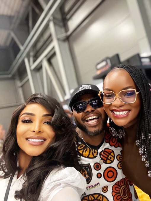 The image features three people posing for a photo, with two women and one man. The woman on the left has long hair and is wearing a white shirt, while the other woman on the right also has long hair and is dressed in an orange and black patterned top. The third person, who appears to be balding, is wearing glasses and a baseball cap. They are all smiling for the camera, creating a fun and lighthearted atmosphere.

The image is related to the post because it features a group of people posing together, which could be considered as a "family" or "friend" moment captured in time. The caption provided also seems to be about this specific photo, possibly indicating that they are sharing their experience with others through social media platforms like Instagram.