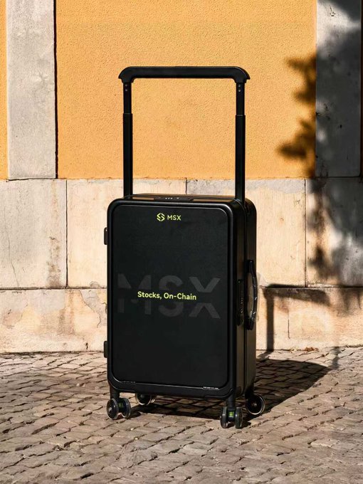 A black MSX suitcase labeled "Stocks, On-Chain" stands on a cobblestone street against a yellow wall. The post appears to announce lucky winners of an MSX airdrop giveaway, with the suitcase pictured as the promotional prize being gifted to the top commenters.