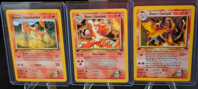 Three custom Pokemon trading cards featuring 'Blaine's Charmander' at 50 HP, 70 HP, and 100 HP are displayed side-by-side in protective sleeves.