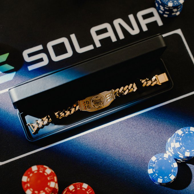 A gold bracelet watch engraved with '2026' sits in a black presentation box on a Solana-branded mat, surrounded by red and blue poker chips.