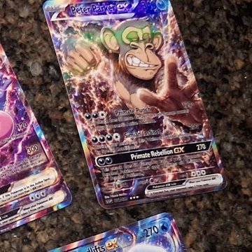 The image features three Pokemon cards, each with a different color scheme - purple, blue, and pink. The card in focus has a purple background and a cartoon monkey character wearing a green hat. The other two cards are also colorful but have different designs. One of them is a pink card with a cartoon monkey on it, while the other one is a blue card featuring a cartoon monkey as well. The post about Peter Parker NFT seems to be related to these Pokemon cards and possibly discussing their value or rarity among collectors.