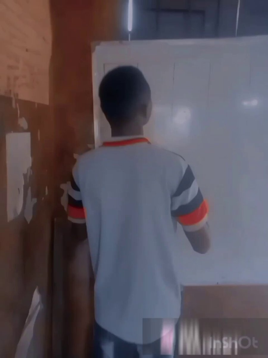The image shows a man wearing a white shirt with orange and red stripes standing next to a whiteboard or board. The man appears to be writing something down on the board, possibly taking notes during a meeting or brainstorming session. The focus of the image is on the man's actions rather than any additional elements in the scene.