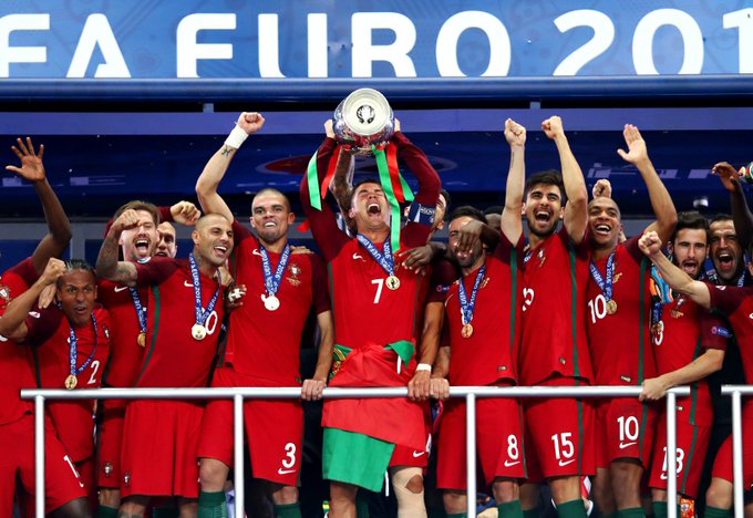 The Portugal national football team in red kits celebrating on a podium with the FIFA Confederations Cup trophy held aloft by Cristiano Ronaldo (wearing #7), with the banner 'FIFA FIIRO 201' partially visible behind them.