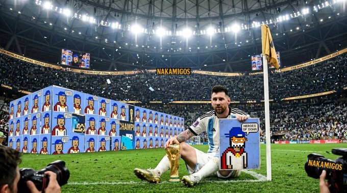 Lionel Messi sitting on the pitch with the World Cup trophy, surrounded by pixel-art 'NAKAMIGOS' characters in a stadium; 'FIFA WORLD CUP Qatar 2022' is visible on the banners.