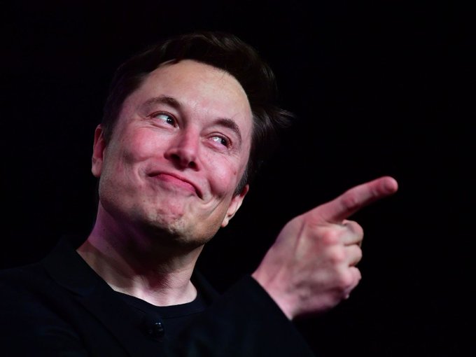 The image features a man with brown hair, wearing a black shirt, pointing his finger towards something out of frame. There are no other objects or people visible in the picture. The caption "Simple trilliionare @elonmusk" is written below the photo and refers to the person who took it.