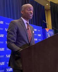 Federal Reserve Vice Chair Philip Jefferson stands at a podium delivering remarks, with "NABP" visible in the background. The image aligns with the post highlighting his scheduled speaking engagement focused on inflation, the U.S. economy, and Treasury markets.