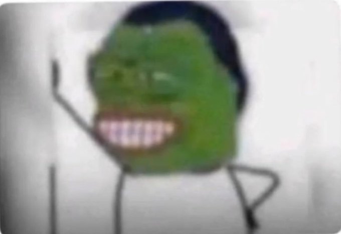 A blurry, distorted meme image showing a figure with a green face and wide grinning teeth.