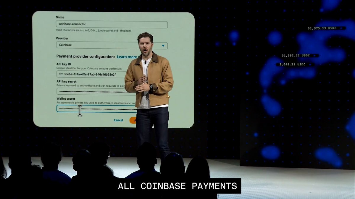 The image shows a man standing at a podium with a presentation screen behind him displaying information about coinbase payments. The text on the screen reads "All Coinbase Payments". This suggests that the speaker is discussing the topic of coinbase payments, possibly focusing on the benefits and advantages of using this payment method for merchants.