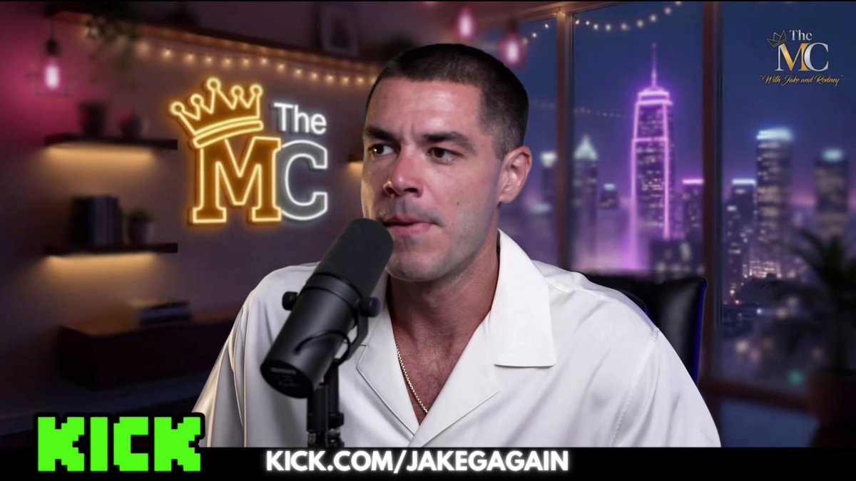 The image features a man wearing a white shirt, sitting behind a microphone with his face visible as he speaks into it. He appears to be talking about kick.com/jakegains.