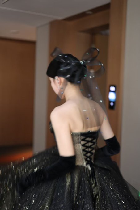 A woman in an elegant black-and-silver wedding gown and long gloves walks through a doorway, likely during wedding photos. The caption highlights the couple’s four-year journey and assets earned through BSC crypto investing and friends made since 2021.