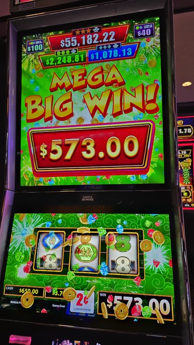 A slot machine displaying 'MEGA BIG WIN!' with a total of '$573.00', showing cash denominations of $1, $2, $5, $10, $50, $100, and $500, and a 'Game Over' screen below.