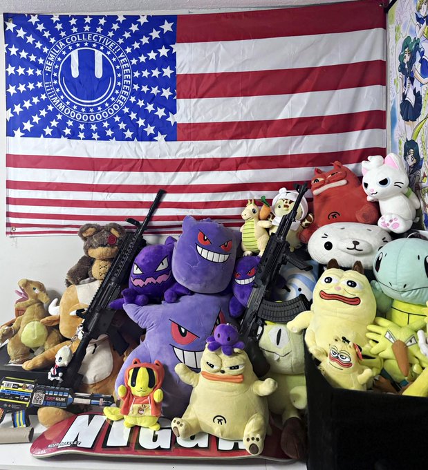 A collection of plush toys displayed in front of a US flag tapestry, including Gengar Pokémon plushies, with real firearms placed among the stuffed animals.