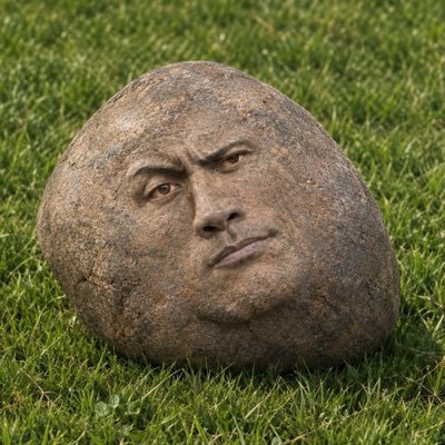 A carved stone with a human face sits on green grass, serving as a creative mascot for the @RockSol2 account promoting their $50 SOL giveaway. The rock's expression gives it a fun, anthropomorphic charm that fits the playful "RockSol" branding, inviting followers to like, repost, and drop their SOL address to enter.