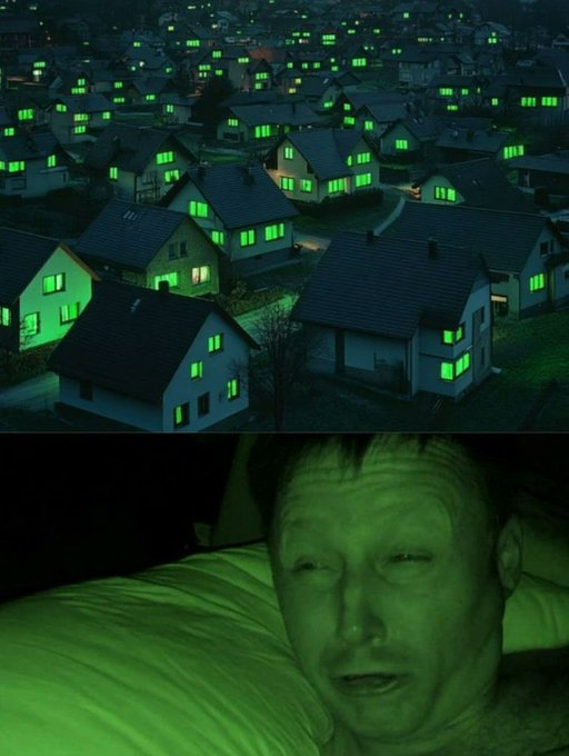 A nighttime scene of a residential neighborhood with houses featuring glowing green windows, above an image of a man lying in bed with a green hue.