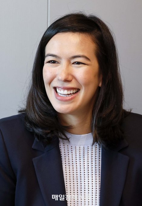 A woman with shoulder-length dark hair smiles broadly while wearing a black blazer over a light grey textured top, appearing at an event with Korean text "매일경제" (Maeil Business Newspaper) visible at the bottom. The image accompanies a quote from Fiona Murray, Ripple's Managing Director for Asia Pacific, discussing how financial institutions in Asia are integrating digital assets and seeking unified solutions for custody, issuance, and governance.