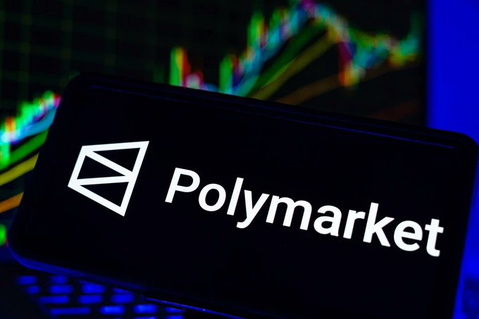 The Polymarket logo displayed on a smartphone screen with colorful financial trading charts visible in the background.
