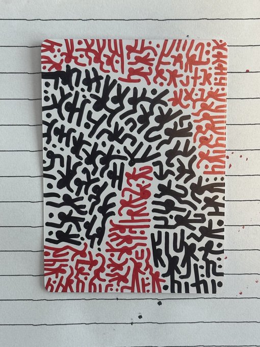 A photograph of a small canvas or paper artwork featuring an abstract pattern of black and red Keith Haring-style figures (lines, shapes, and dots) placed on a lined notebook page.