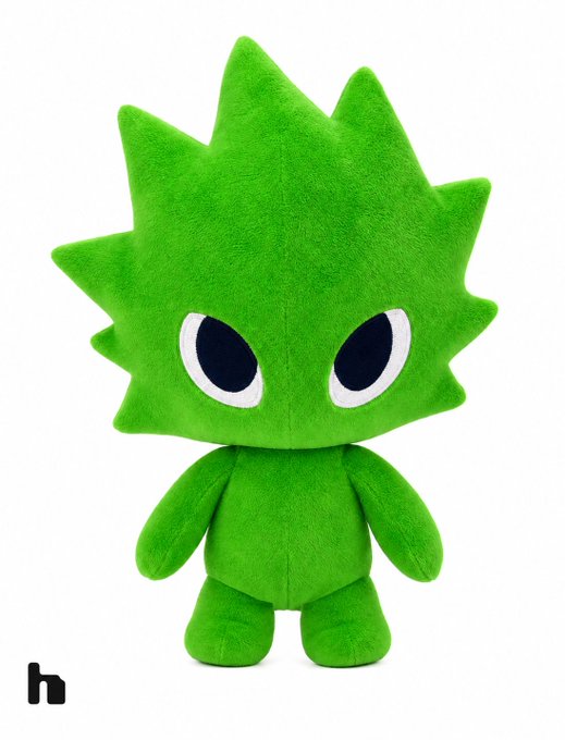 A green plush toy character with a spiky, leaf-shaped head and large expressive eyes is displayed against a white background, with a small 'h' logo in the bottom left corner.