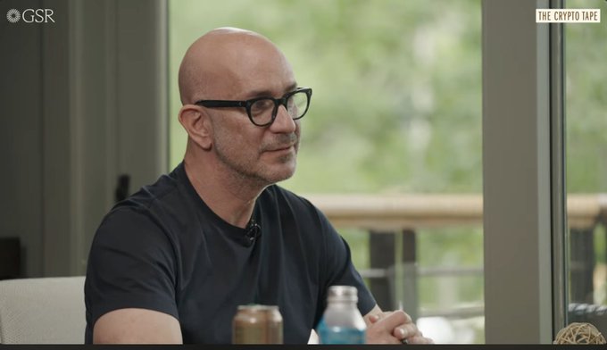 Carlos Domingo, CEO of Securitize, appears on "The Crypto Tape" interview by GSR, wearing a black t-shirt and glasses while seated with a beverage. The image complements the discussion about his argument that tokenizing even a small fraction of the global equities market could match crypto's current size.