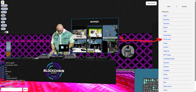 A CryptoVoxels interface displays a DJ at a "BLOCKCHAIN RADIO" setup broadcasting live, with an arrow highlighting the new "Womps" wall feature in the right sidebar menu that showcases the last 6 womps for a parcel. The "womps" gallery above the DJ shows thumbnail images of recent womps displayed on a purple-patterned wall, demonstrating the customizable feature mentioned in the post.