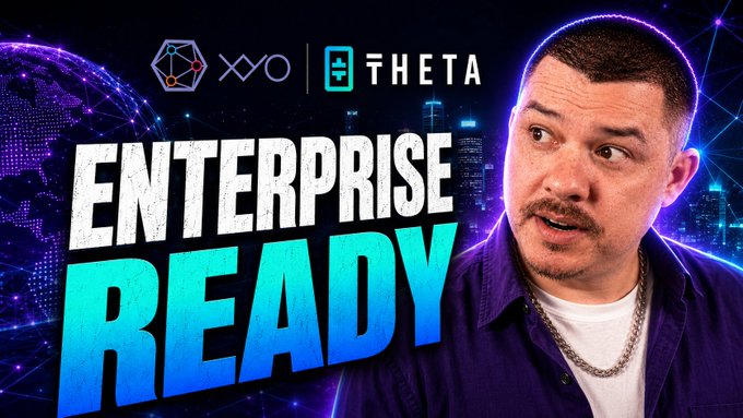 The image features a man with a mustache wearing a purple shirt, who appears to be talking about an upcoming project or event related to the company "THEta" and another company named "XYO". The text in the image reads "Enterprise Ready", which suggests that they are discussing plans for implementing new technology or strategies.