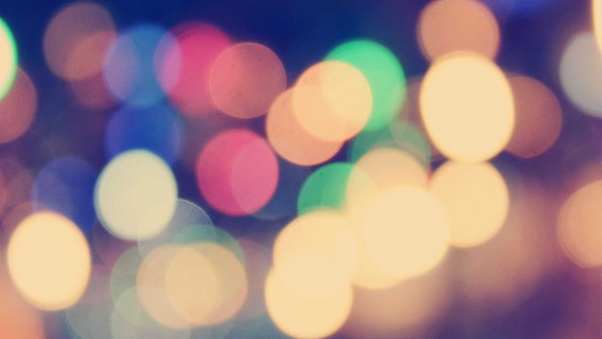 The image shows a close-up view of a blurred background with numerous colorful lights, resembling a night sky or festive atmosphere. The focus of the image is on the details of these lights, which are scattered throughout the frame. There is no discernible text in the image, and it does not provide any information about the post's content.
