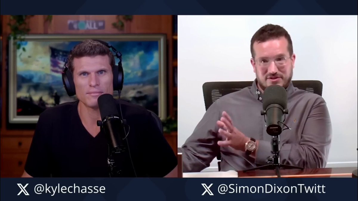 The image shows two men sitting behind microphones, one wearing headphones while the other has his hands up. They appear to be engaged in a conversation or discussion about something related to cryptocurrency. The caption above them reads "MicroStrategy is not fighting Wall Street. @SimonDixonTwitt says Strategy is part of the financial industrial complex. Wrapping Bitcoin in a Wall Street wrapper is not resistance. Self-custody is." This suggests that they are discussing how certain strategies or tactics can be used to combat the influence of Wall Street and the financial industry, using the example of Bitcoin as an illustration.