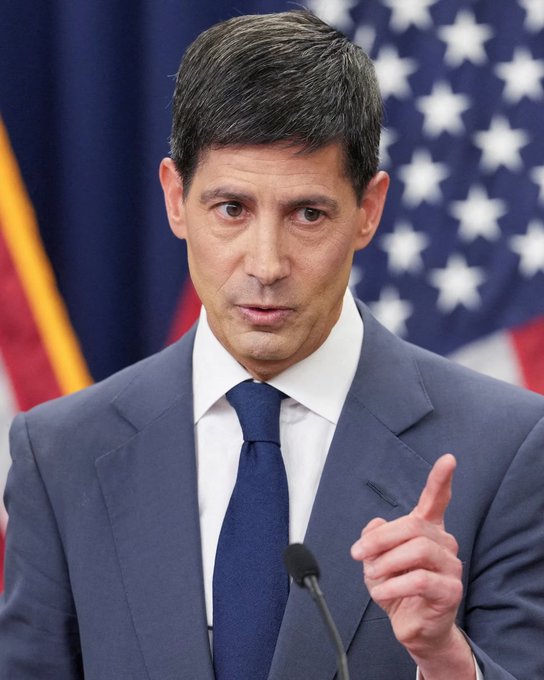 A man in a navy suit and blue tie gestures while speaking at a podium, with an American flag visible behind him, as he delivers remarks amid growing market expectations of a Federal Reserve rate hike. The image likely relates to a Federal Reserve official addressing monetary policy expectations ahead of the September FOMC decision.